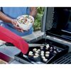 Person grillt Jakobsmuscheln auf einer Grillplatte