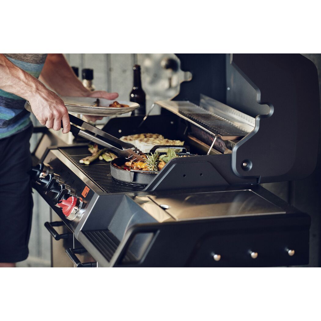 Person grillt mit Grillzange auf dem Gasgrill Monroe