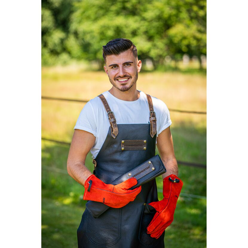 Person mit Grillschürze und Handschuhen
