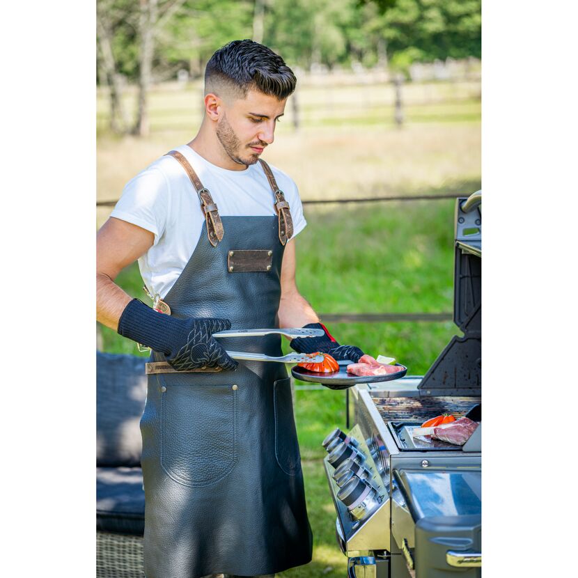 Person grillt Fleisch und Gemüse