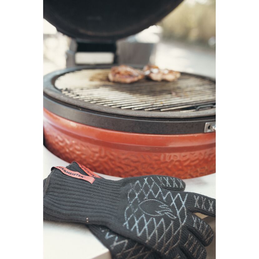 Grillhandschuhe und Grill mit Fleisch
