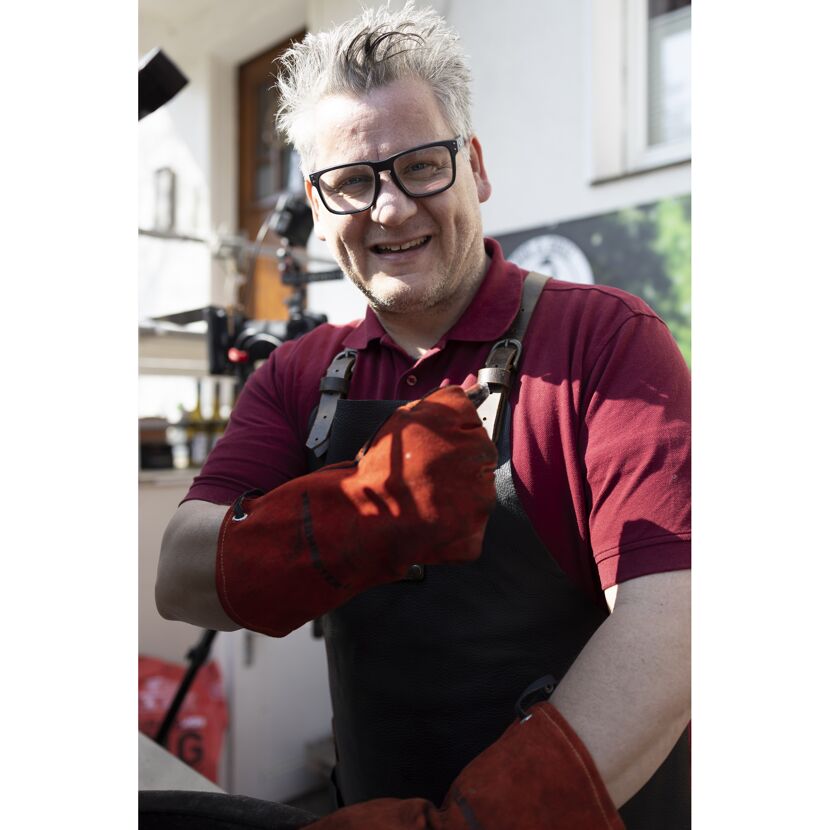 Person mit Grillhandschuhen