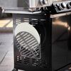 Grillrost und Pizzastein im Unterschrank eines Gasgrills
