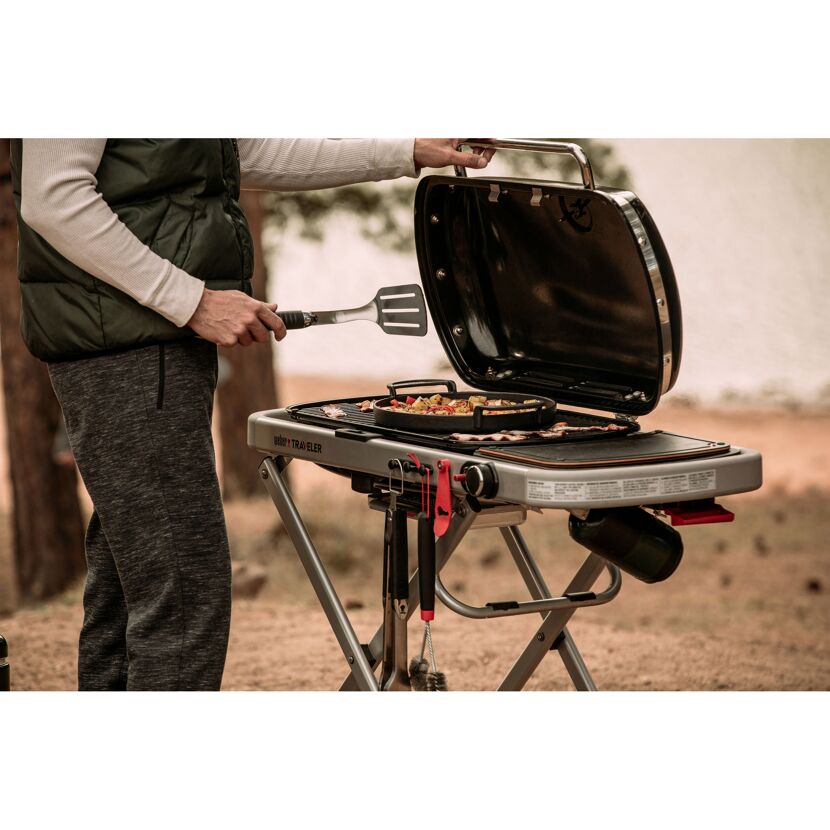 Person grillt auf einem Weber Traveler Gasgrill.