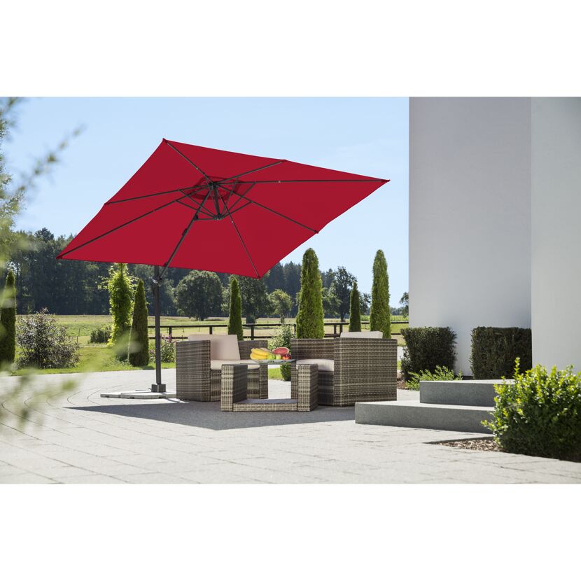 Roter quadratischer Sonnenschirm über Sitzgruppe im Garten