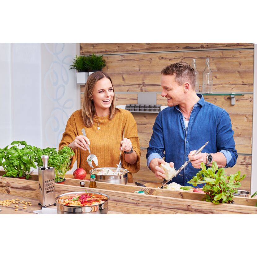 Zwei Personen beim Kochen mit Reibe