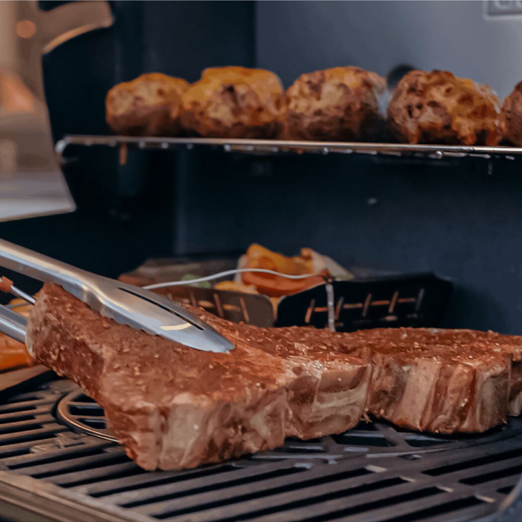 Steak wird mit einer Grillzange gewendet