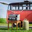 Tragbarer Gasgrill vor einem Campingbus.