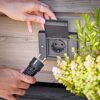 Person steckt Stecker in Steckdose von Gira