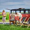 Zwei Personen grillen mit einem Rösle Gasgrill vor einem VW-Bus.