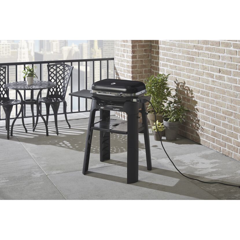 Schwarzer Weber Lumin Elektrogrill auf einem Balkon.