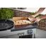 Person legt Weber Butcher Papier auf einen Grill.
