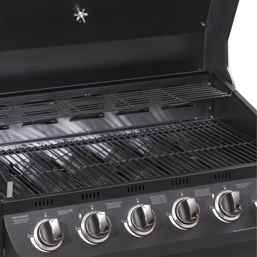Innenansicht eines schwarzen Gasgrills mit vier Brennern.