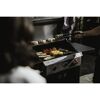 Person grillt Gemüse, Steaks und Baguette auf einem Gasgrill