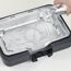 Wasser wird in einen Tischgrill gegossen