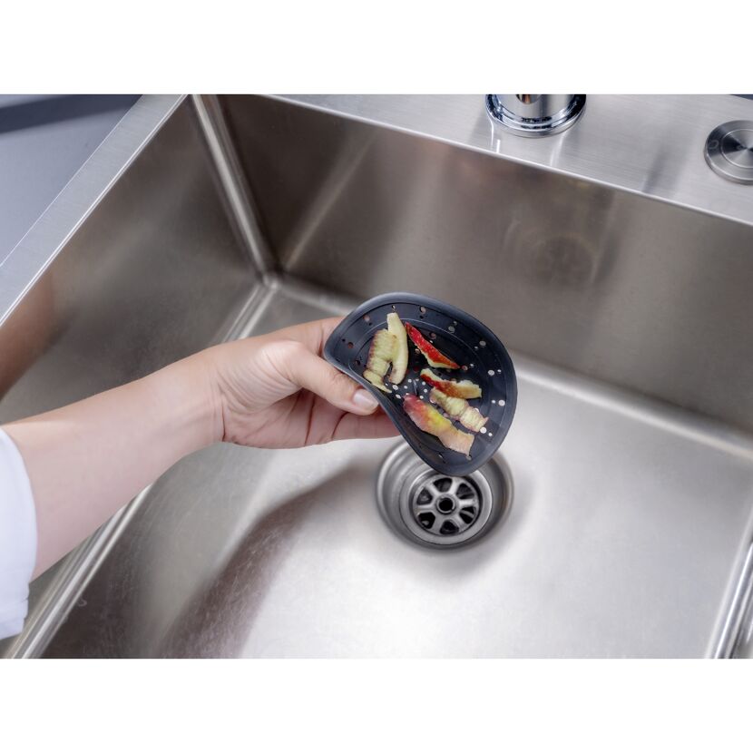 Hand hält Abfluss-Sieb über Spüle
