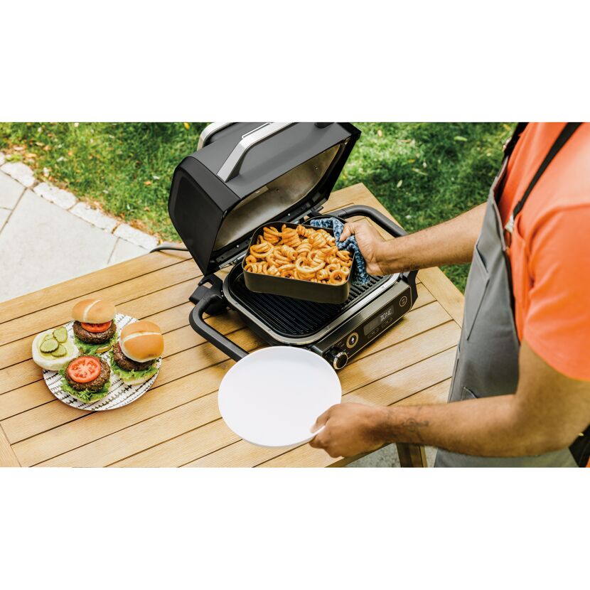 Person bereitet Mahlzeit auf Elektrogrill zu