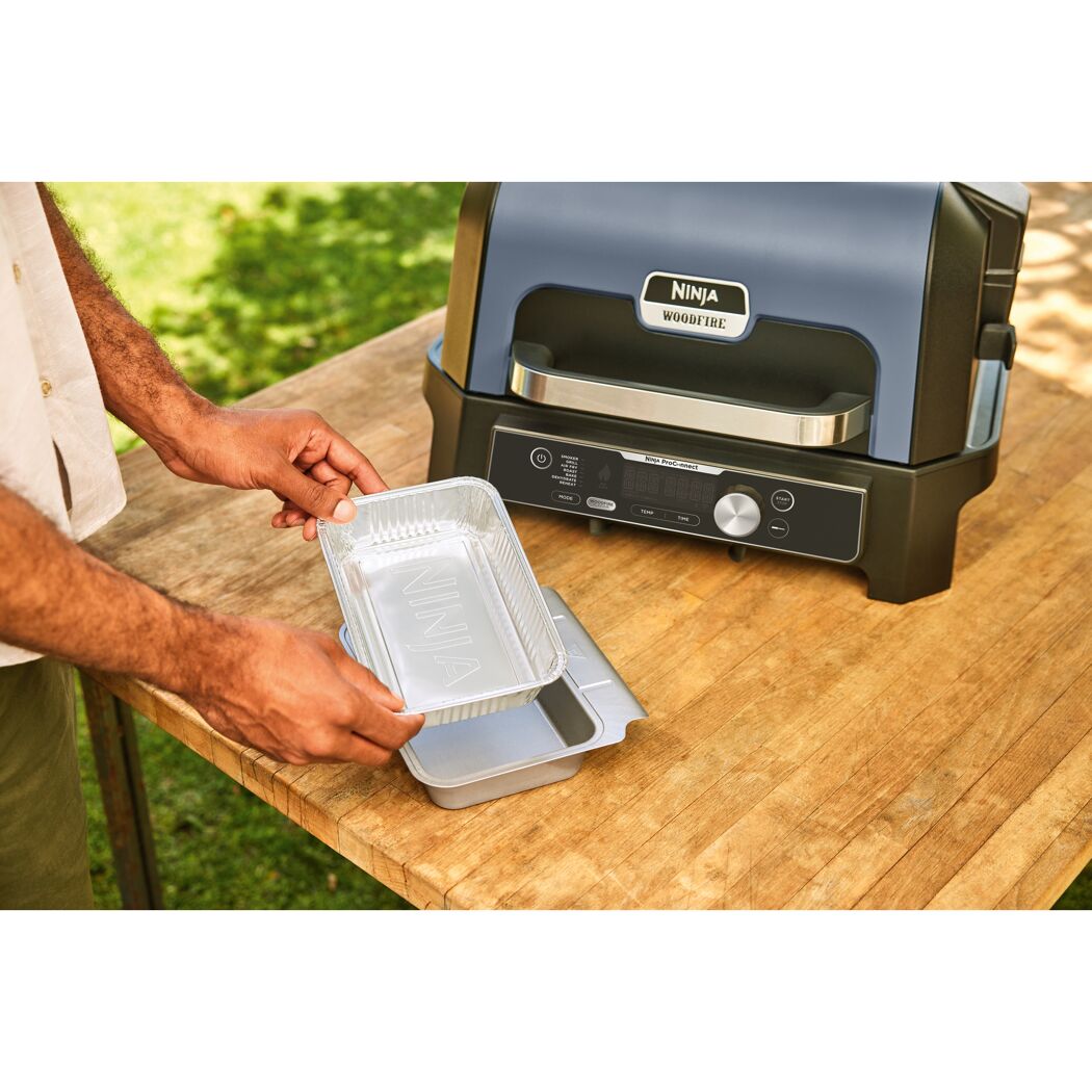 Person bereitet Ninja Woodfire Grill vor