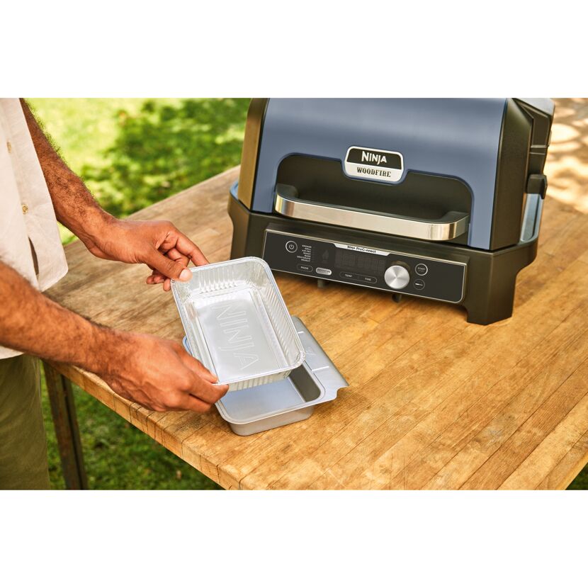 Person bereitet Ninja Woodfire Grill vor