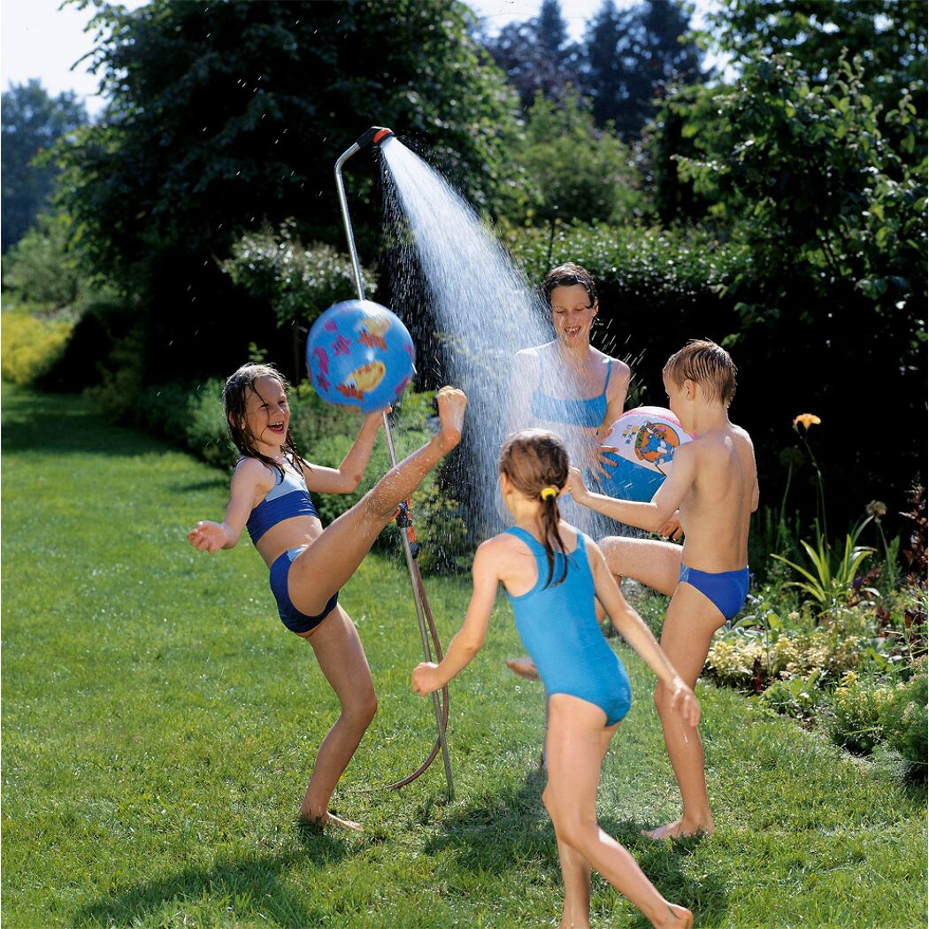 Kinder spielen im Garten mit einer Gartendusche