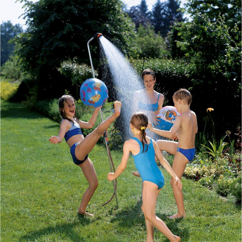 Kinder spielen im Garten mit einer Gartendusche