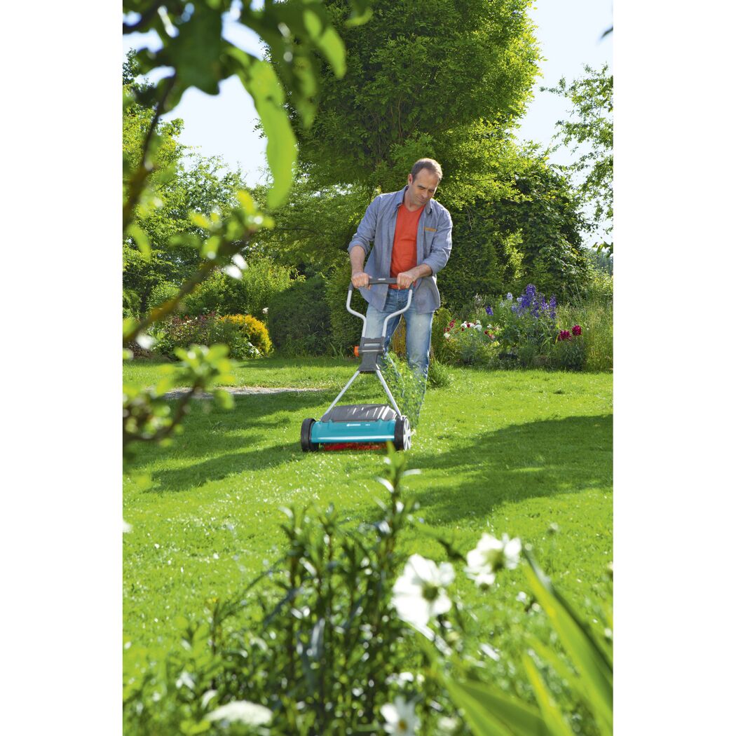 Person mäht Rasen mit Spindelmäher