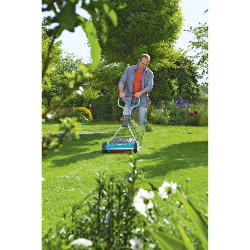 Person mäht Rasen mit Spindelmäher