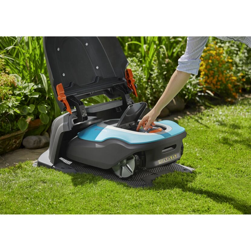 Person bedient Mähroboter GARDENA SILENO