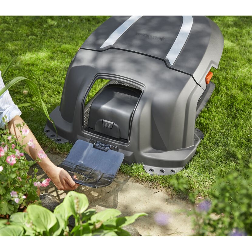 Person öffnet die Gardena Mähroboter-Garage.