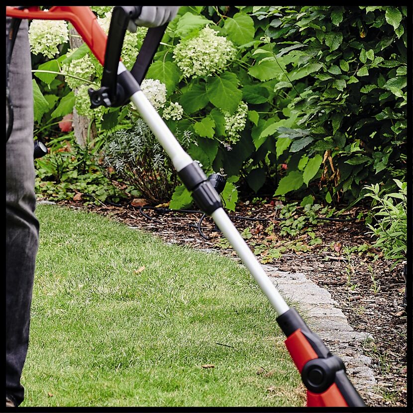 Person verwendet Rasentrimmer im Garten