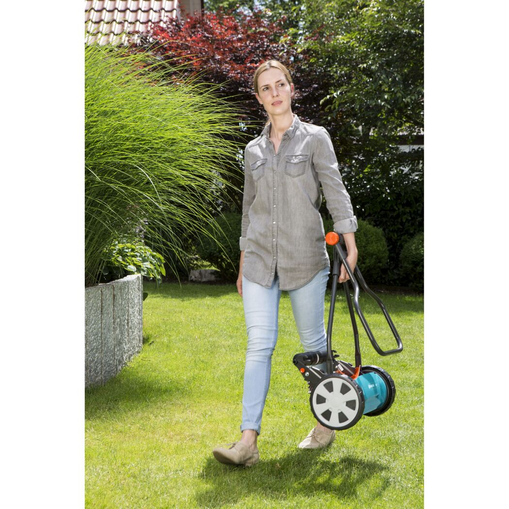 Person mäht Rasen mit Spindelmäher