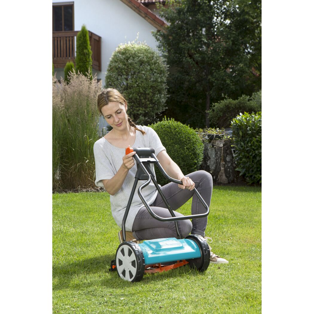 Person mäht Rasen mit Spindelmäher