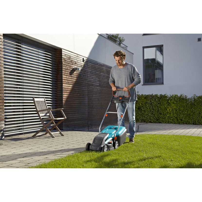 Person mäht Rasen mit GARDENA PowerMax 1400/34.