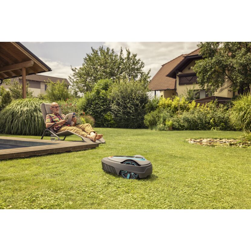 Person entspannt am Pool, während Mähroboter SILENO city 400 den Rasen mäht.