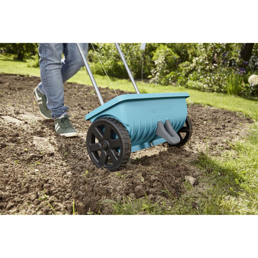 Person verwendet einen Streuwagen von Gardena.