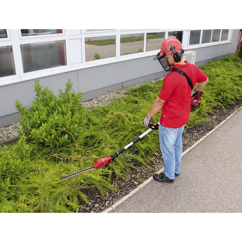 Person schneidet Hecke mit Akku-Teleskop-Heckenschere