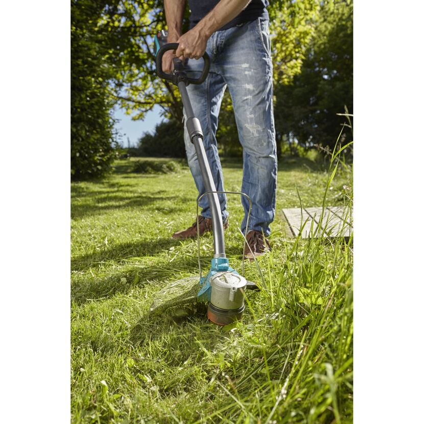 Person mäht Rasen mit Akku-Trimmer PowerCut Li-40/30