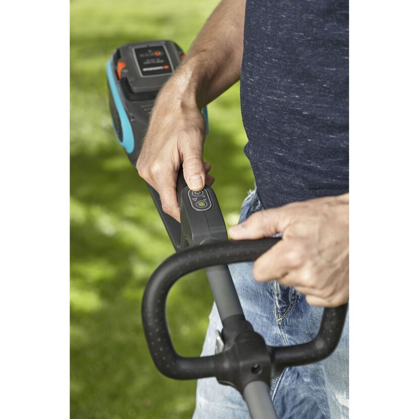 Person verwendet einen Akku-Trimmer.