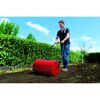 Person verwendet Rasenwalze im Garten