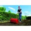 Person verwendet Rasenwalze im Garten