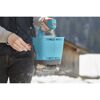 Person streut mit blauem Handstreuer