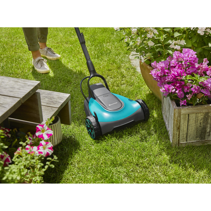 Person mäht Rasen mit Gardena Akku-Mäher.