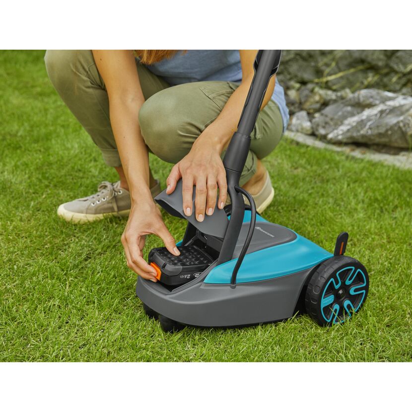 Person setzt Akku in Gardena HandyMower ein