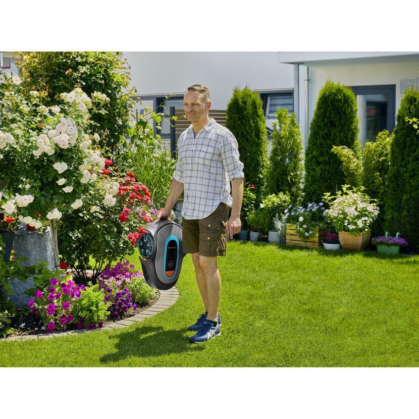 Person hält Mähroboter SILENO minimo im Garten