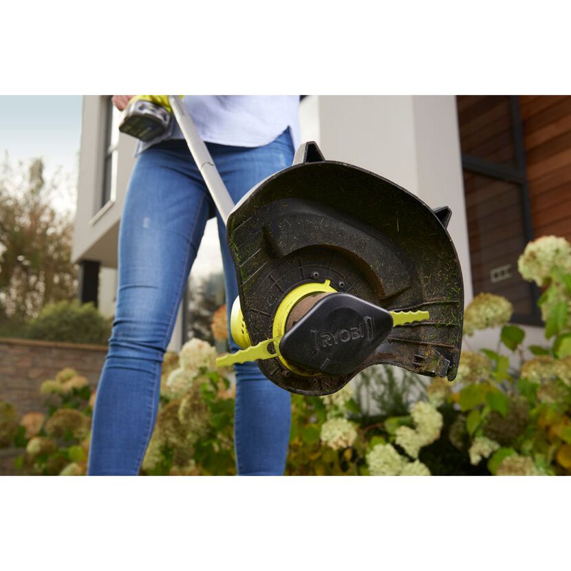 Person verwendet Rasentrimmer von Ryobi.