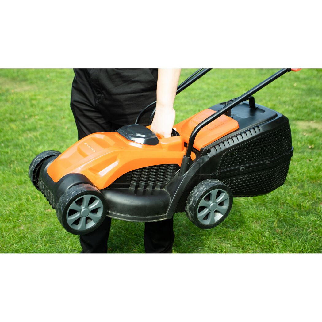 Person trägt orange-schwarzen Akku-Rasenmäher.
