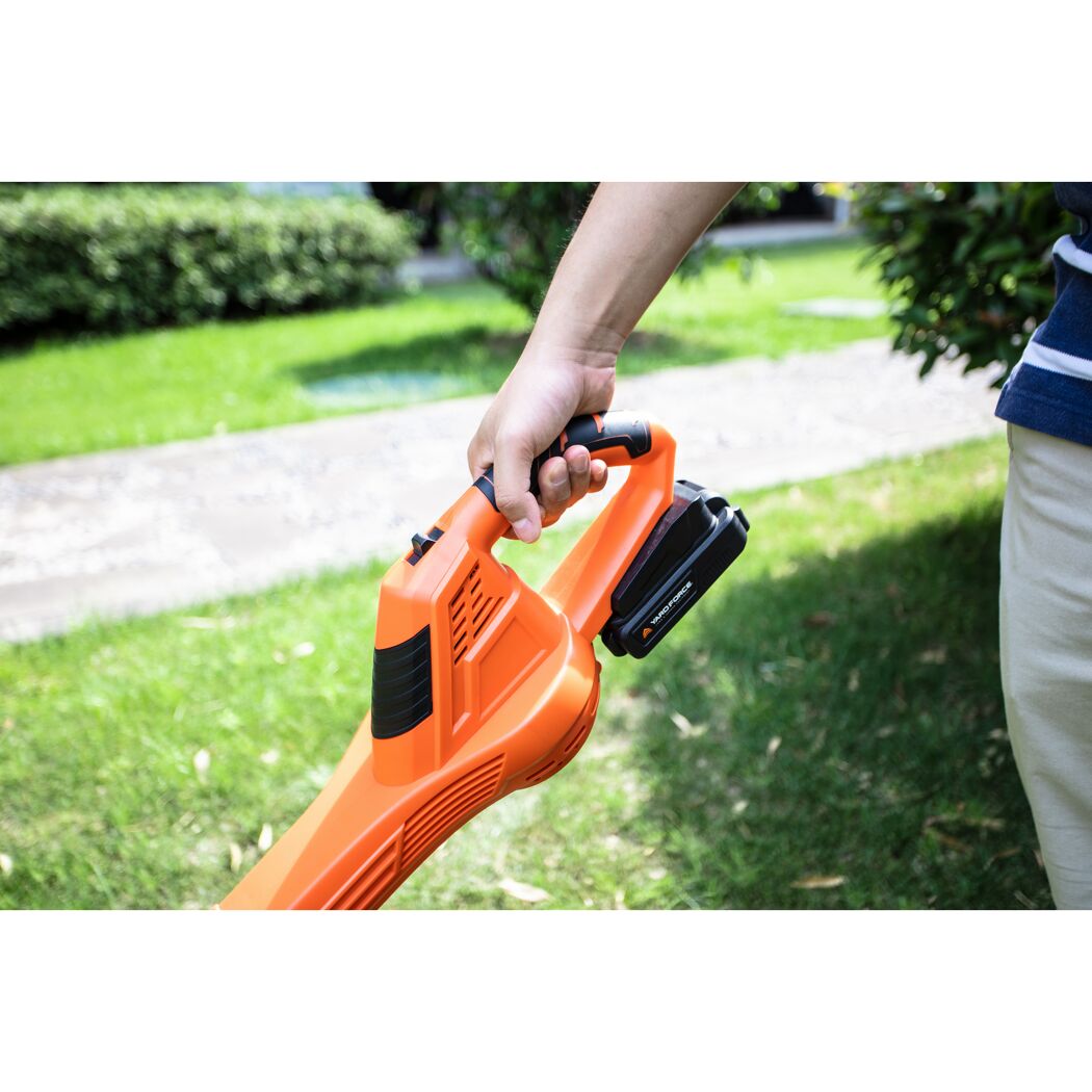 Person hält einen orangefarbenen Laubbläser