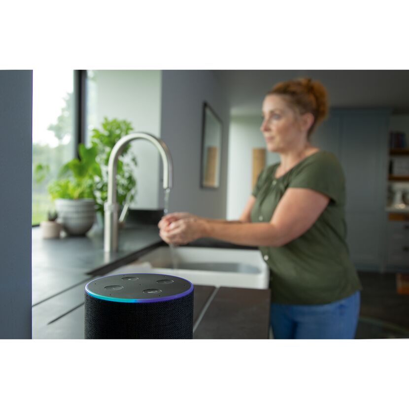 Person wäscht Hände, Amazon Echo im Vordergrund