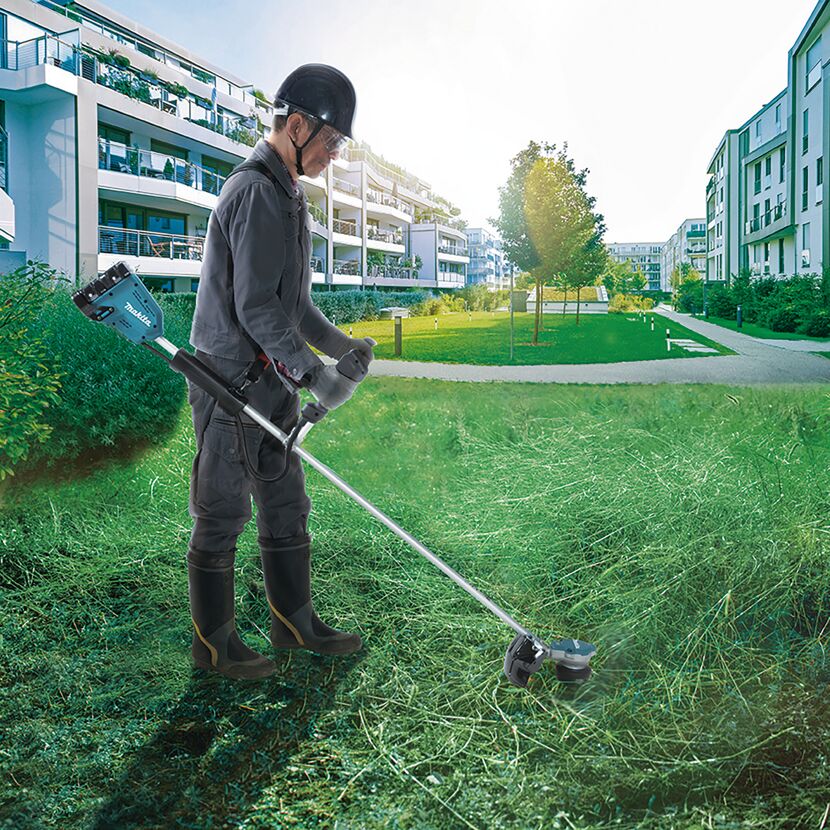 Person mäht Rasen mit Akku-Rasentrimmer