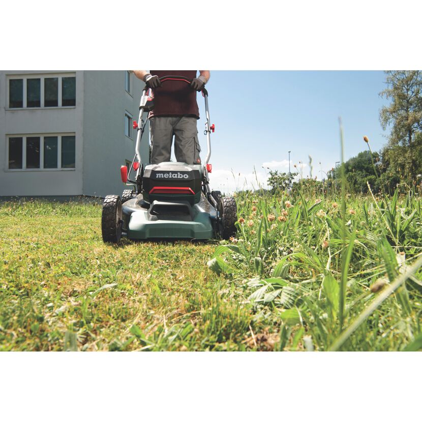 Person mäht Rasen mit einem Metabo Rasenmäher.
